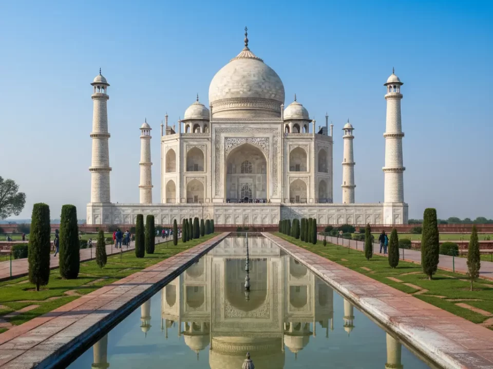 “Taj Mahal in Agra, white marble monument reflecting in the Yamuna River under a clear blue sky”